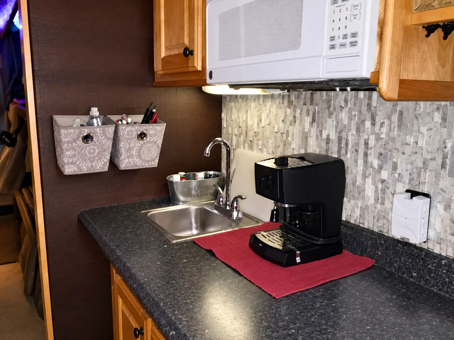 Compact tour bus kitchenette with sink, microwave and coffee maker