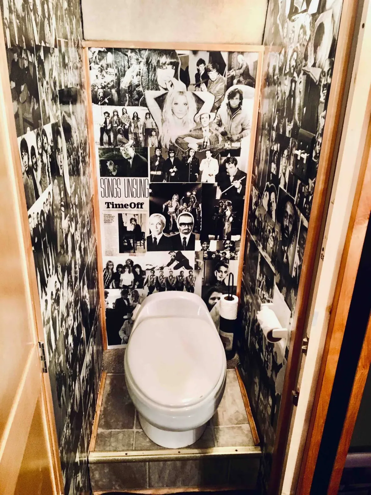 Real toilet inside the vintage Eagle tour bus with black-and-white music photo walls